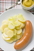 Frankfurter with potato salad, mustard in small dish