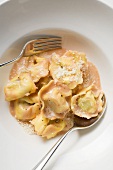 Tortellini with tomato cream sauce and Parmesan on plate