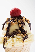 Cone of nut ice cream with chocolate sauce and raspberry