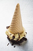 Cone of nut ice cream with chocolate sauce (upside down)
