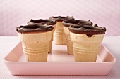 Empty chocolate-dipped ice cream cones on pink tray