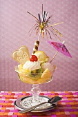 Ice cream sundae with fresh fruit and cocktail umbrella