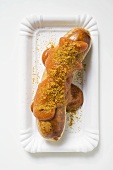 Sausage with ketchup and curry powder on paper plate