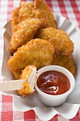 Chicken nuggets with ketchup in paper dish