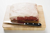 Sirloin steak on chopping board with knife