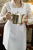Chambermaid holding silver pot