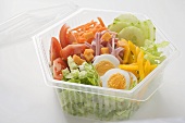 Iceberg lettuce, ham, cheese, egg & vegetables in plastic bowl