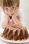Small boy looking at ring cake with coloured chocolate beans
