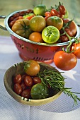 Verschiedene Tomaten in Holzschale und Fussseiher