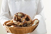 Chambermaid serving soft pretzels in bread basket