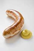 Sausage (bratwurst) with mustard on white background