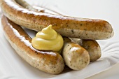 Sausages (bratwursts) with mustard on paper plate