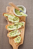 Bruschetta with avocado spread on chopping board (overhead)