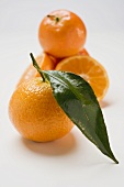 Several clementines, whole and halved, with leaf