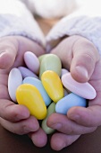 Child's hands holding sugared almonds