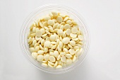 White chocolate chips in plastic tub (overhead view)