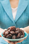 Woman holding dish of dates