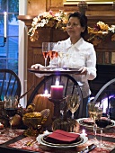 Table laid for Thanksgiving, woman serving sparkling wine (USA)