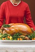 Woman holding roast turkey on large platter