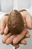 Hands holding chocolate Easter egg