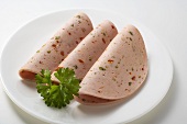 Three slices of Pikantwurst (sausage with red & green pepper)