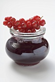 Jar of redcurrant jelly, fresh redcurrants on top of jar