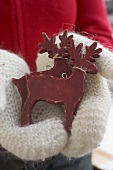 Hands in mittens holding two reindeer (Christmas decorations)