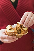 Woman halving a muffin in a paper case