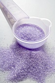 Purple sugar, some in measuring spoon