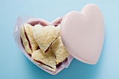 Heart-shaped jam-filled biscuits in pink container
