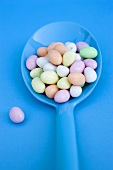 Sugar eggs on blue spoon (overhead view)