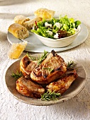 Grilled pork chops with rosemary, salad leaves and bread