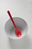 Red spoon in white bowl