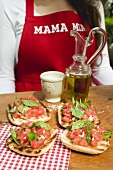 Bruschetta with tomato salsa, woman in background