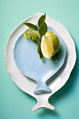 Weisser und blauer fischförmiger Teller, dekoriert mit Zitronen