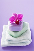 Two bars of soap with orchid on towel