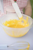Child stirring egg mixture with spatula