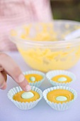 Coloured muffin mixture in muffin cases