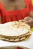 Woman holding a pile of tortillas