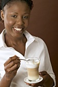 Woman holding glass of latte macchiato