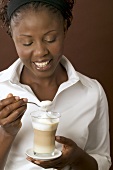 Woman holding a glass of latte macchiato