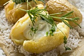 Baked potato with sour cream and herbs on salt