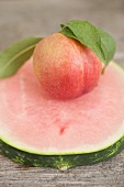 Nectarine with leaves on slice of watermelon