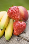 Bananas, strawberries and nectarine on wooden table