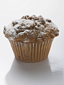 Nut muffin sprinkled with icing sugar in paper case