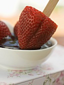 Strawberry on stick in chocolate sauce