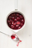 Cherry compote in pan, spoon beside it