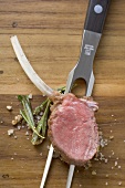 Lamb chop with rosemary and salt on meat fork