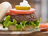 Hamburger with tomato slices, gherkin and onions