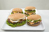 Four cheeseburgers on tray